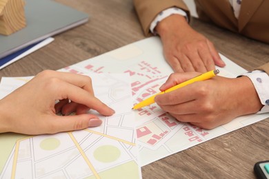 Photo of Real estate agent working with client at wooden table, closeup