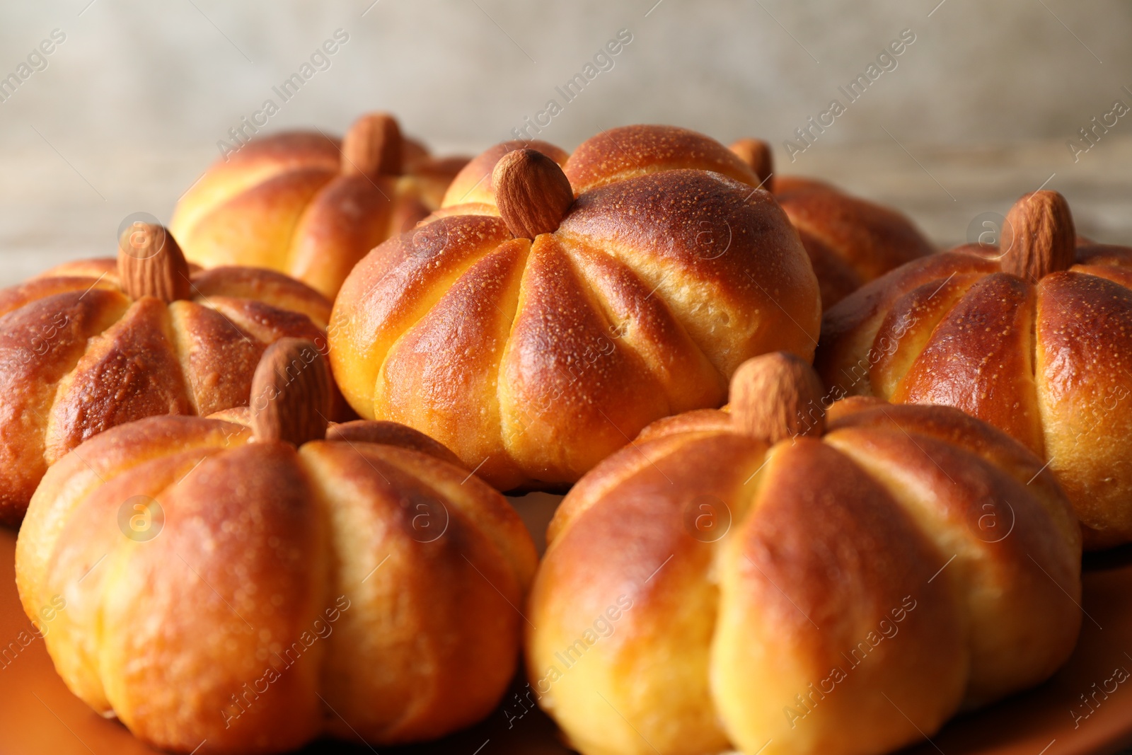 Photo of Tasty pumpkin shaped buns on table, closeup