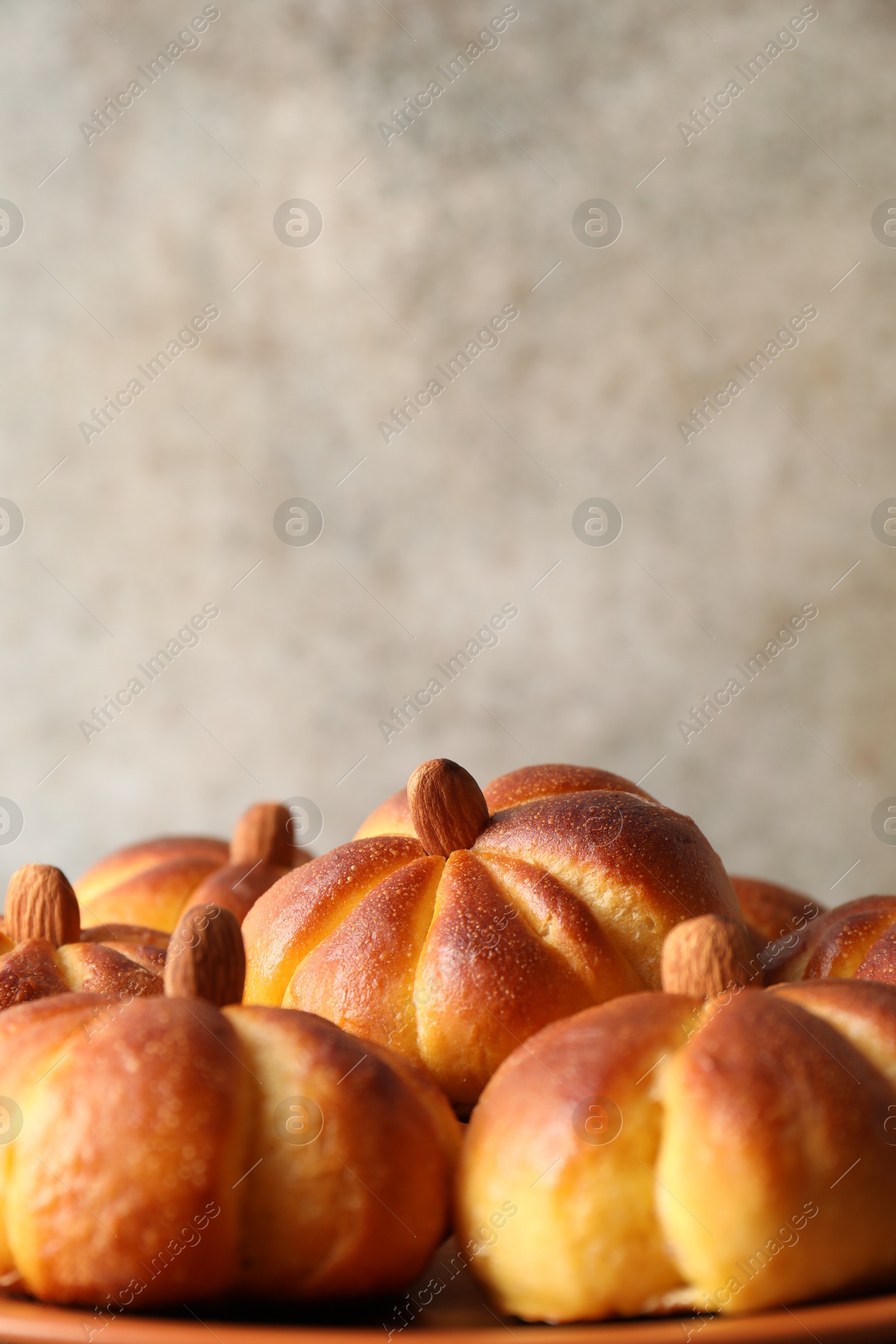 Photo of Tasty pumpkin shaped buns on table, closeup