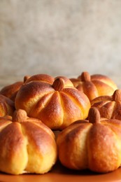 Photo of Tasty pumpkin shaped buns on table, closeup