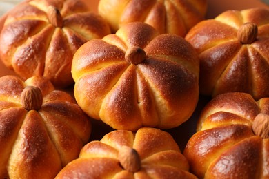 Photo of Tasty pumpkin shaped buns on table, closeup