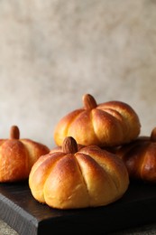 Photo of Tasty pumpkin shaped buns on grey table, closeup