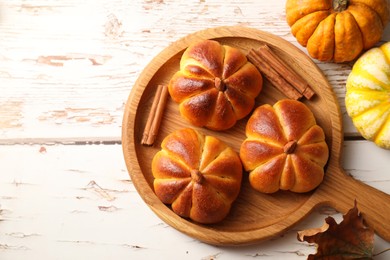 Photo of Tasty pumpkin shaped buns and ingredients on old wooden table, flat lay. Space for text