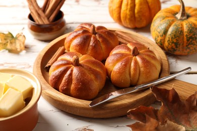 Photo of Tasty pumpkin shaped buns served on old wooden table