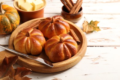 Photo of Tasty pumpkin shaped buns served on old wooden table