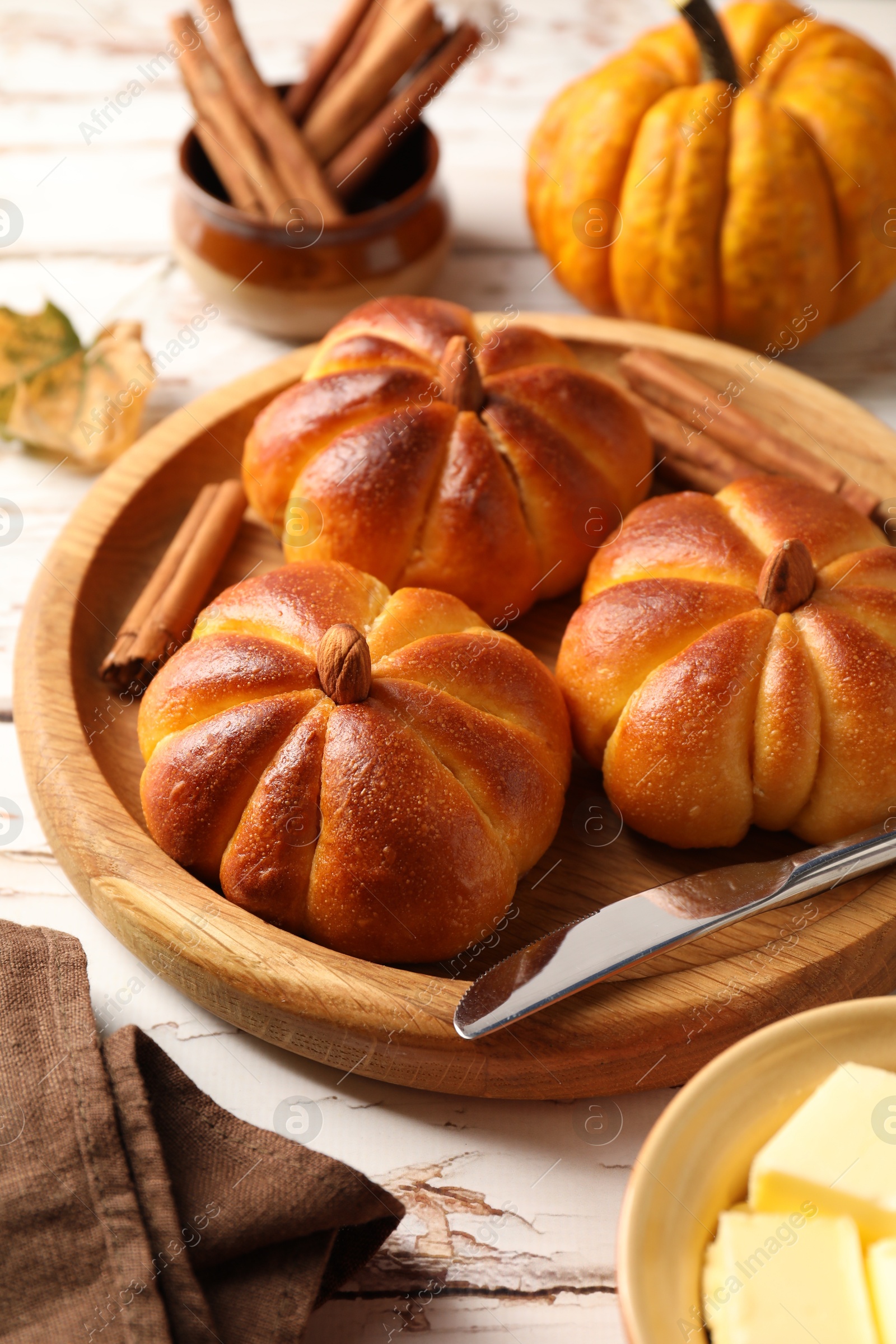 Photo of Tasty pumpkin shaped buns served on old wooden table