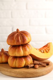 Photo of Tasty pumpkin shaped buns and ingredients on white table, closeup