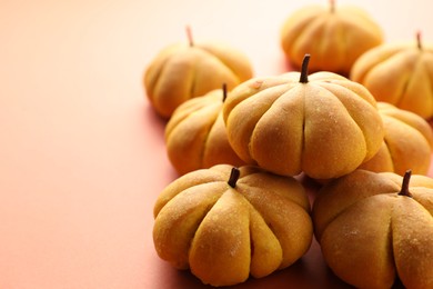 Photo of Pile of tasty pumpkin shaped buns on light background, closeup. Space for text