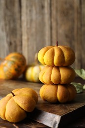 Photo of Tasty pumpkin shaped buns on wooden table