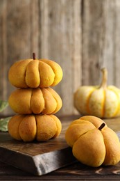 Photo of Tasty pumpkin shaped buns on wooden table