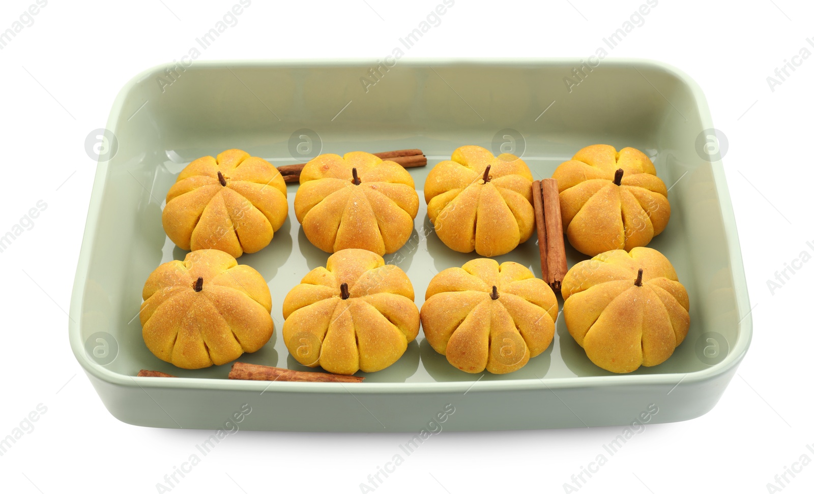 Photo of Baking tray with tasty pumpkin shaped buns and cinnamon sticks isolated on white