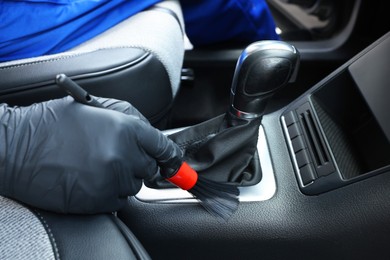 Man cleaning car interior with brush, closeup