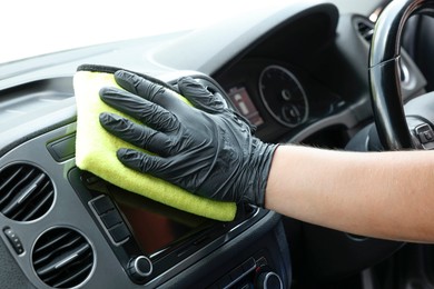 Man cleaning center console with rag, closeup