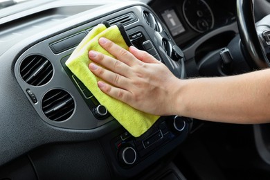 Man cleaning center console with rag, closeup