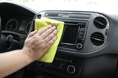 Man cleaning center console with rag, closeup