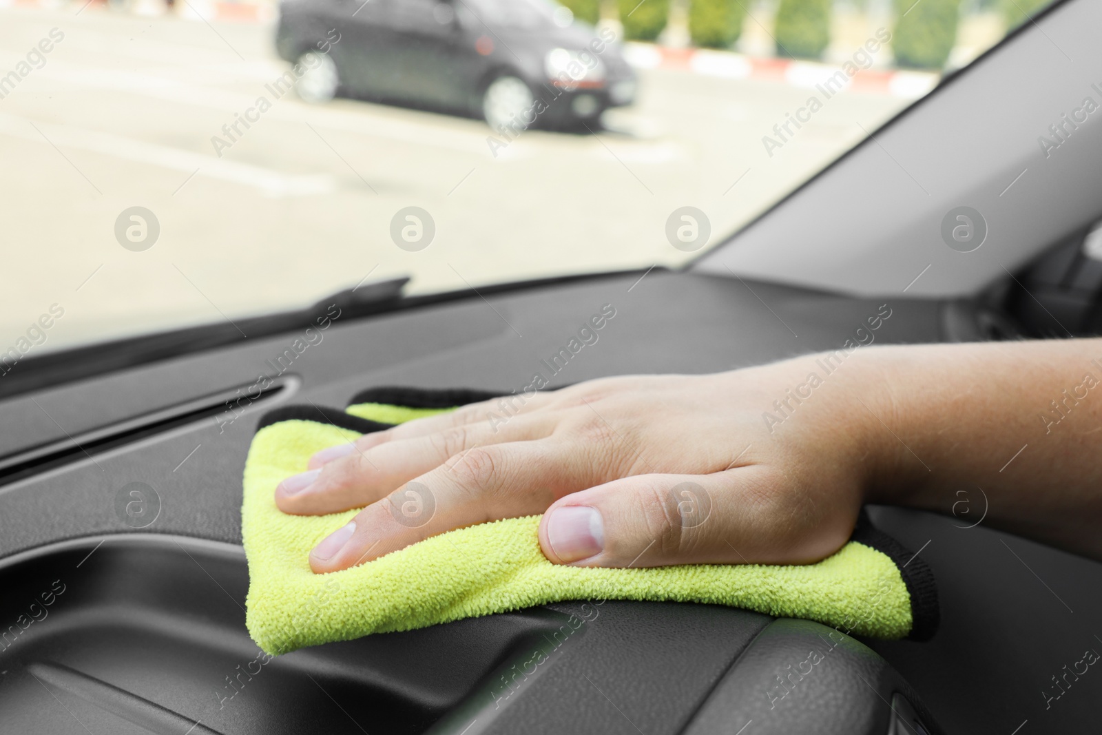 Photo of Man cleaning car interior with rag, closeup