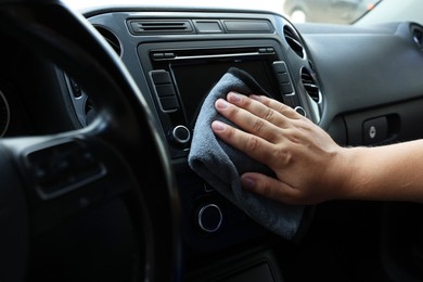 Man cleaning center console with rag, closeup