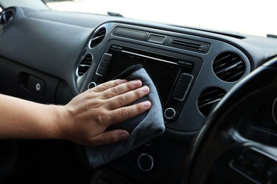 Man cleaning center console with rag, closeup