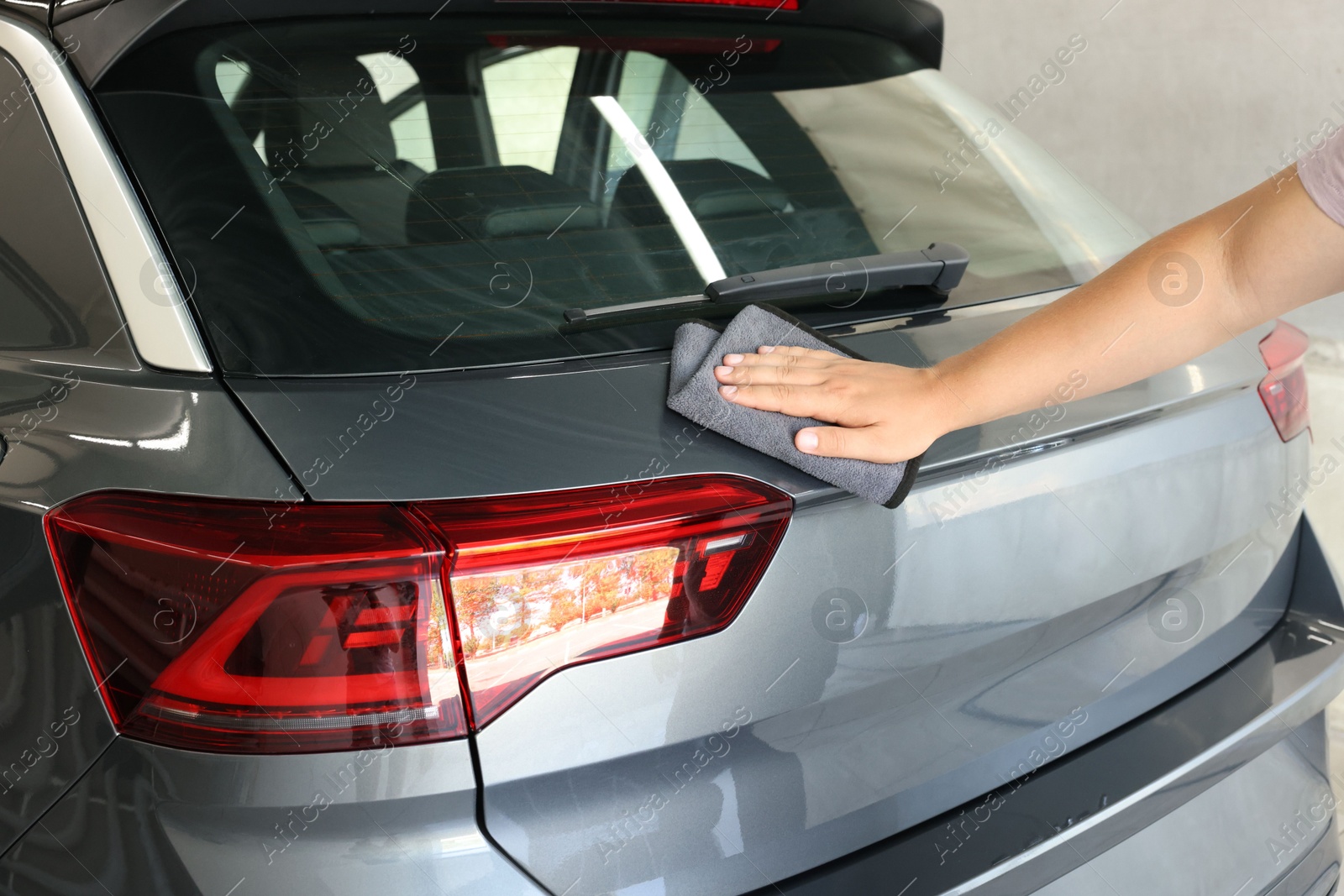 Photo of Man wiping auto with rag at car wash, closeup