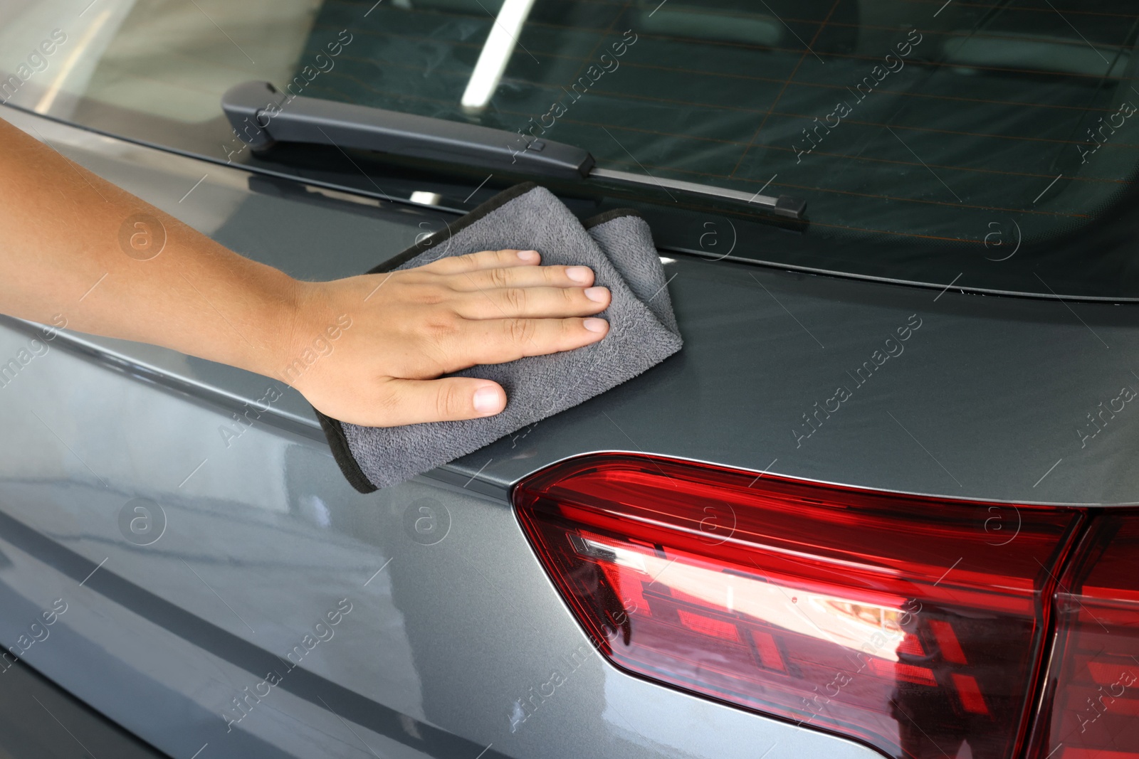 Photo of Man wiping auto with rag at car wash, closeup