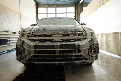 Photo of Auto covered with cleaning foam at car wash