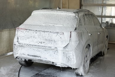 Auto covered with cleaning foam at car wash