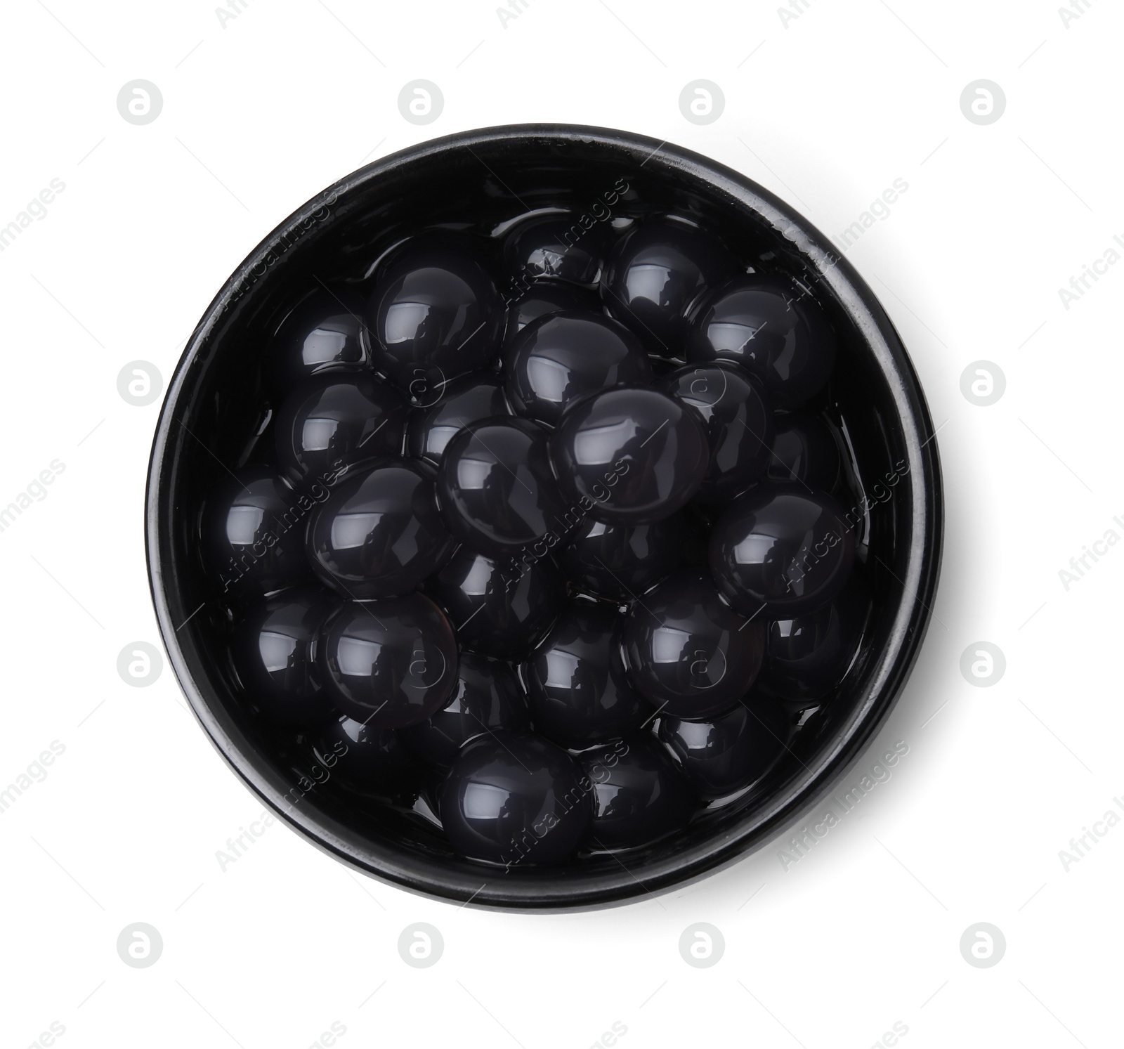 Photo of Dark tapioca pearls in bowl isolated on white, top view