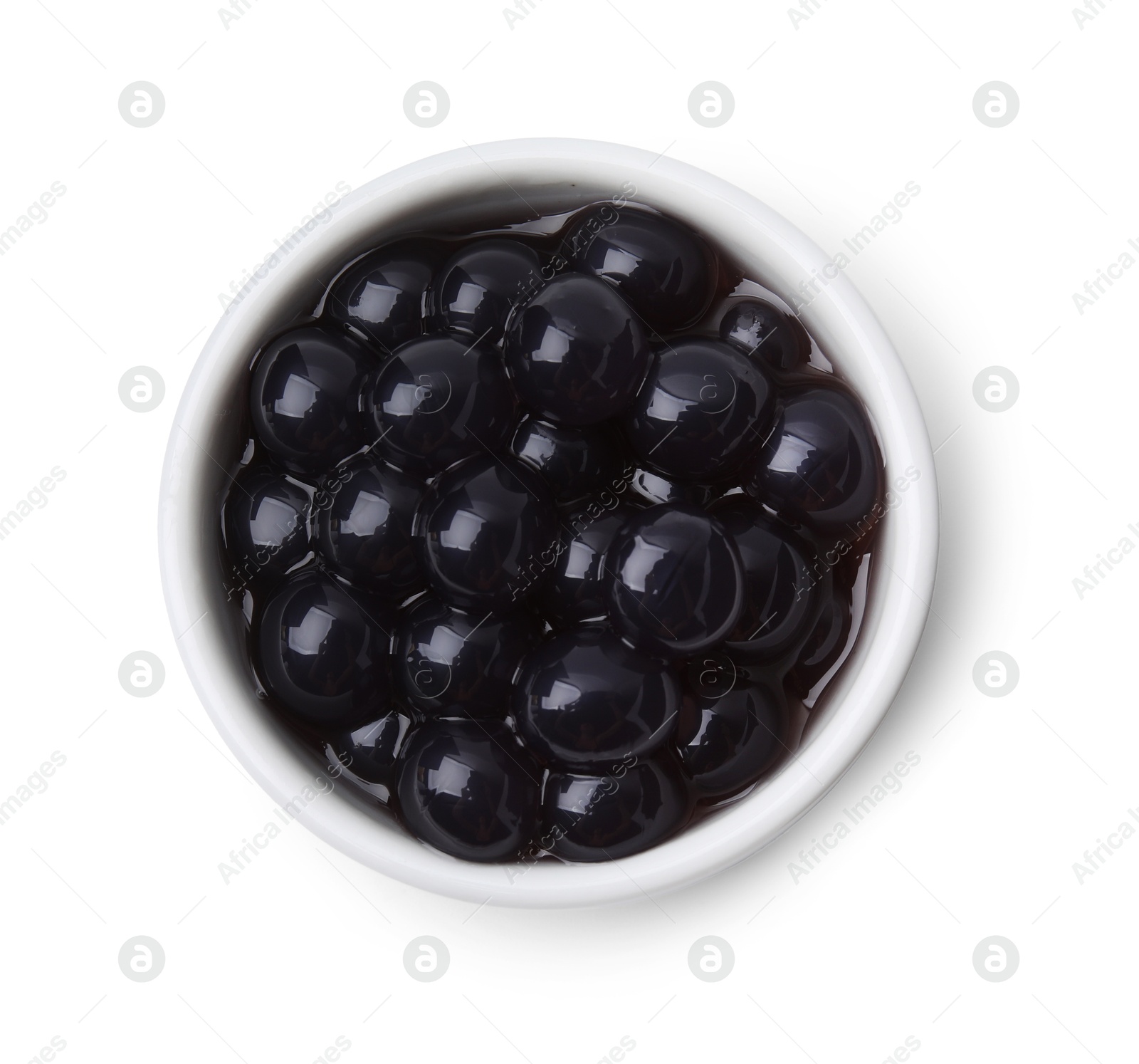 Photo of Dark tapioca pearls in bowl isolated on white, top view