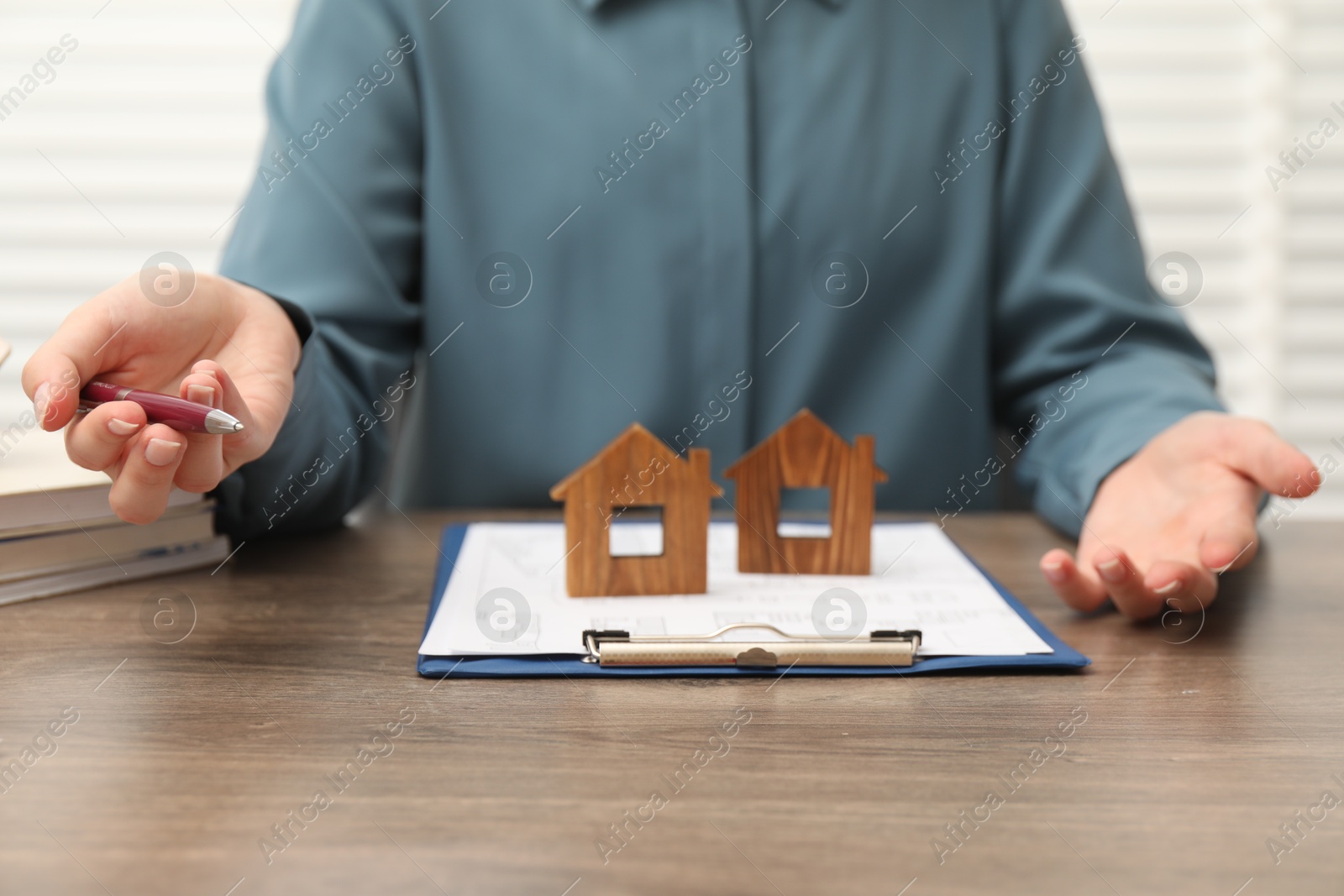 Photo of Real estate agent working at wooden table, closeup