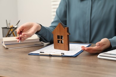 Photo of Real estate agent working at wooden table, closeup