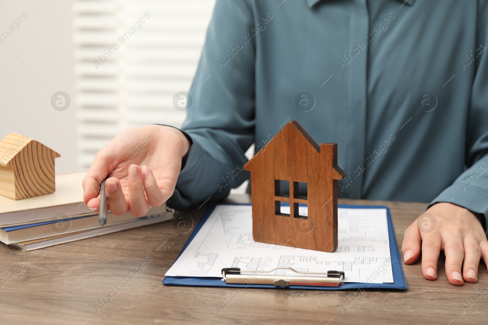 Photo of Real estate agent working at wooden table, closeup