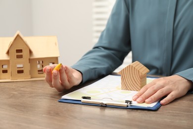 Photo of Real estate agent working at wooden table, closeup