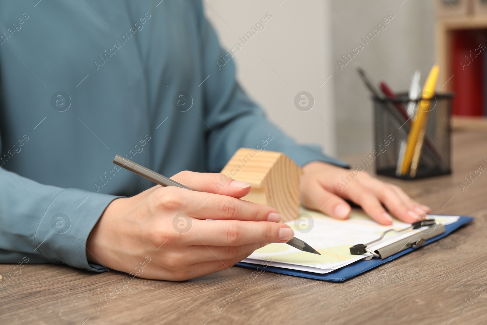 Photo of Real estate agent working at wooden table, closeup