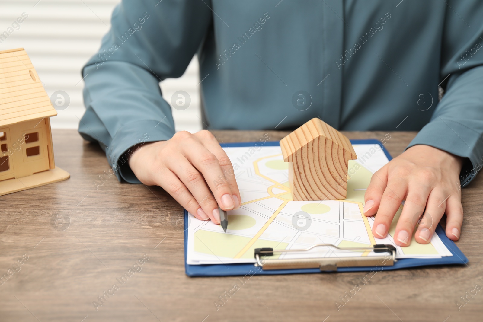 Photo of Real estate agent working at wooden table, closeup