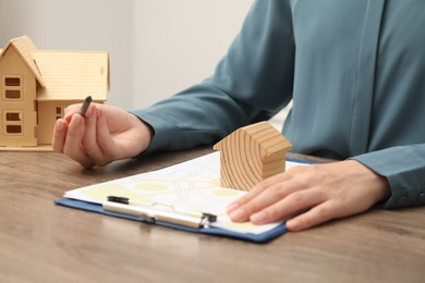 Photo of Real estate agent working at wooden table, closeup