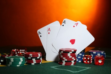 Poker chips, dices and playing cards on green table