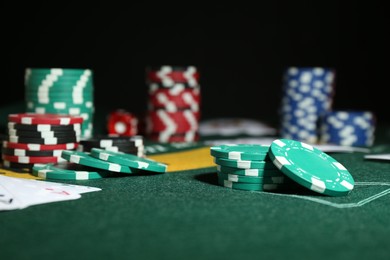 Photo of Poker game. Casino chips on green table, closeup