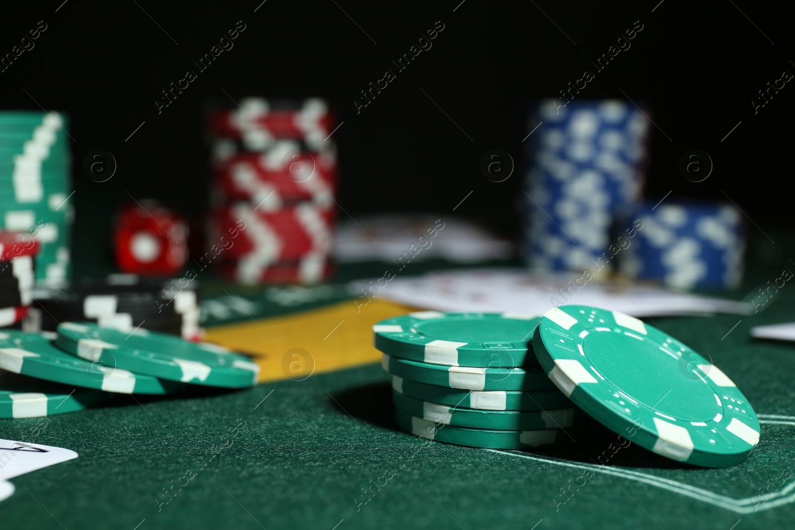 Photo of Poker game. Casino chips on green table, closeup