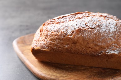 Photo of Tasty sponge cake with powdered sugar on grey table, closeup