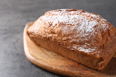 Photo of Tasty sponge cake with powdered sugar on grey table, closeup