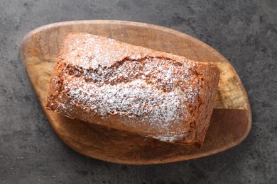 Photo of Tasty sponge cake with powdered sugar on grey table, top view