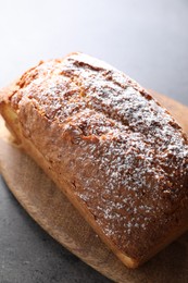 Photo of Tasty sponge cake with powdered sugar on grey table, closeup