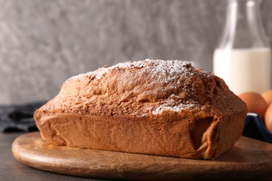 Photo of Tasty sponge cake with powdered sugar on grey table, closeup