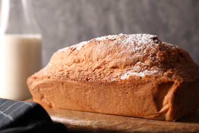 Photo of Tasty sponge cake with powdered sugar on table, closeup