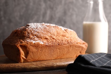 Photo of Tasty sponge cake with powdered sugar on grey table, closeup