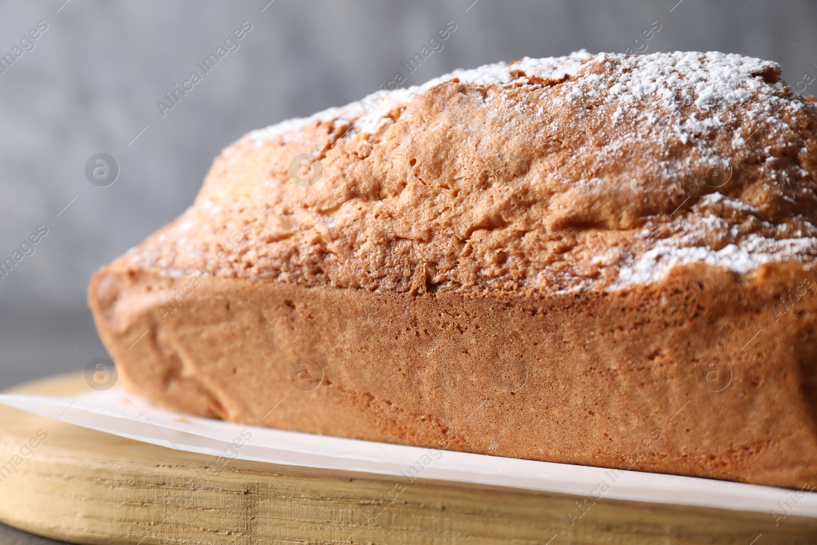 Photo of Tasty sponge cake with powdered sugar on table, closeup