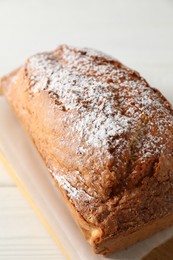 Photo of Tasty sponge cake with powdered sugar on white table, closeup