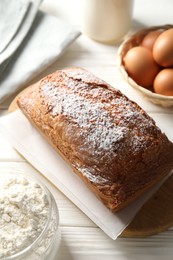 Photo of Tasty sponge cake with ingredients on white wooden table