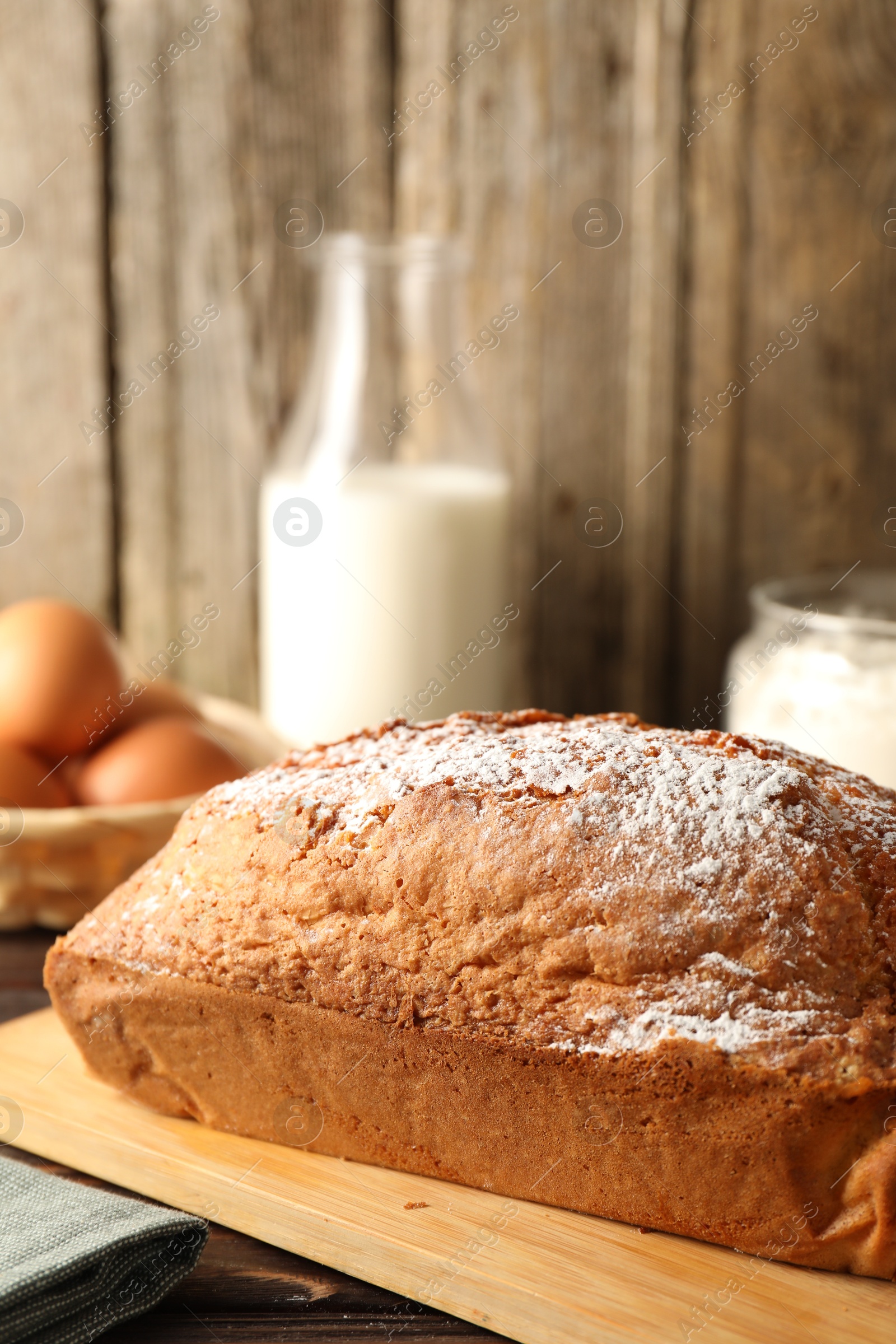 Photo of Tasty sponge cake with powdered sugar on table, closeup