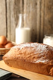 Photo of Tasty sponge cake with powdered sugar on table, closeup